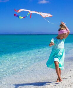 photo une petite fille et son cerf volant sur la plage