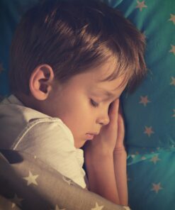 Photo d'un petit garçon qui dort dans son lit