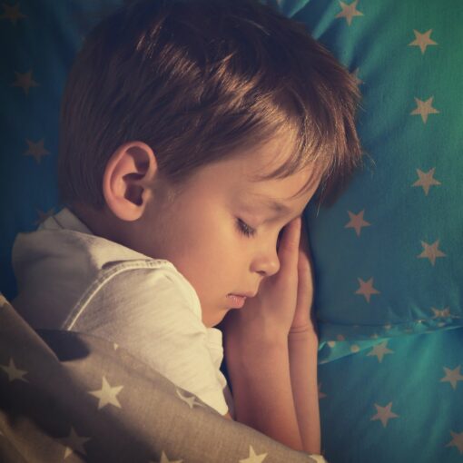 Photo d'un petit garçon qui dort dans son lit